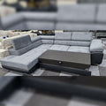 Gray sectional sofa with a coffee table in a showroom setting