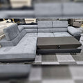 Gray sectional sofa on a checkered floor with blurred background